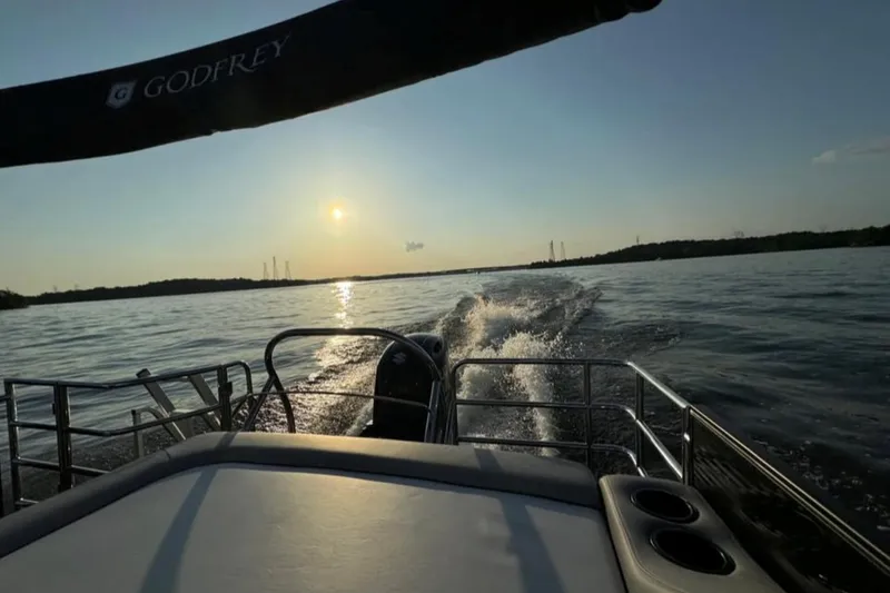 Slide: The Image of 2023 Godfrey Sweetwater 2486 SFL boat cruising on a lake at sunset. - 5
