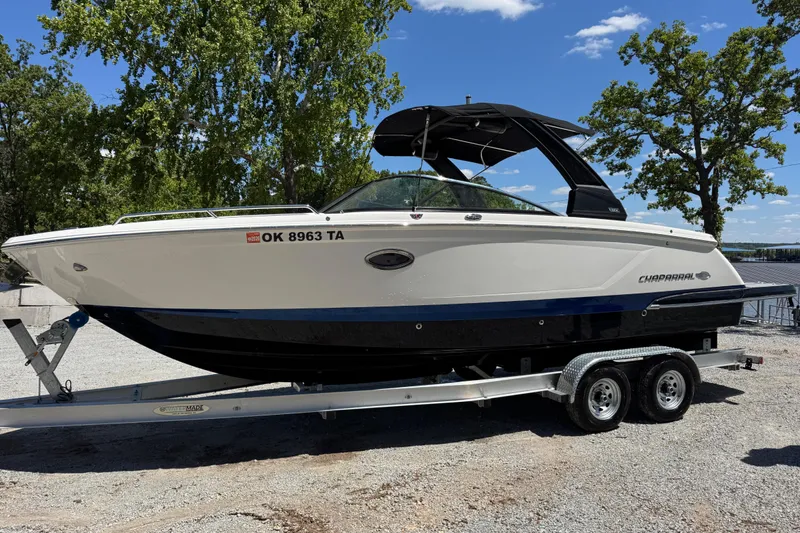 The Image of 2021 Chaparral 287 SSX boat on trailer, parked outdoors under clear sky. - 1