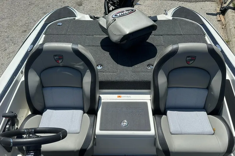 Slide: The Image of 2026 Triton 179 TrX boat interior with dual gray seats and steering wheel. - 10
