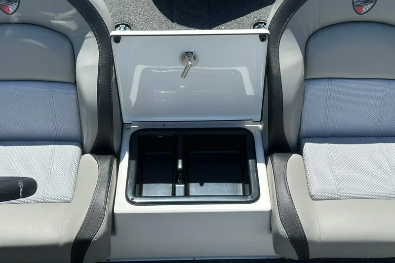 Slide: The Image of 2026 Triton 179 TrX boat interior with open storage compartment between seats. - 17
