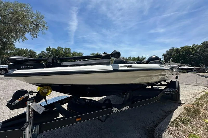 Slide: The Image of 2026 Triton 179 TrX boat on trailer, parked outdoors under clear blue sky. - 2