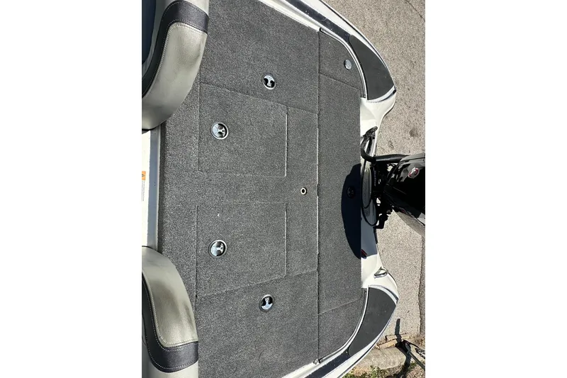 Slide: The Image of 2026 Triton 179 TrX boat deck with gray carpet and storage compartments. - 20