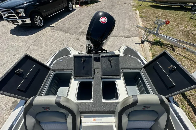 Slide: The Image of 2026 Triton 179 TrX boat interior with open storage compartments and motor view. - 21