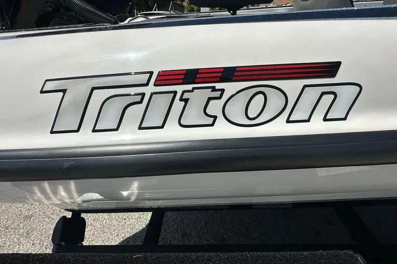 Slide: The Image of 2026 Triton 179 TrX boat logo on white surface, featuring bold lettering and red accents. - 23