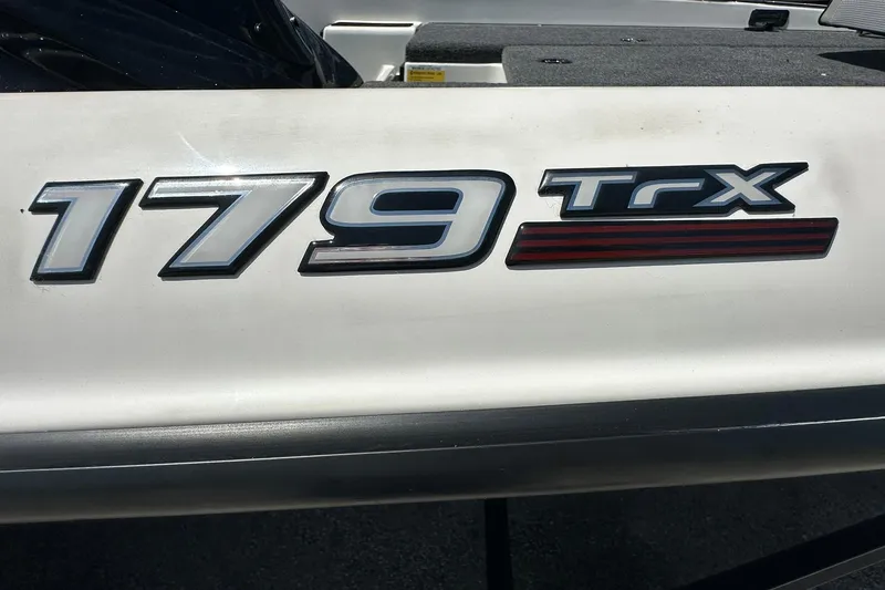 Slide: The Image of Close-up of 2026 Triton 179 TrX boat model emblem on white surface. - 24