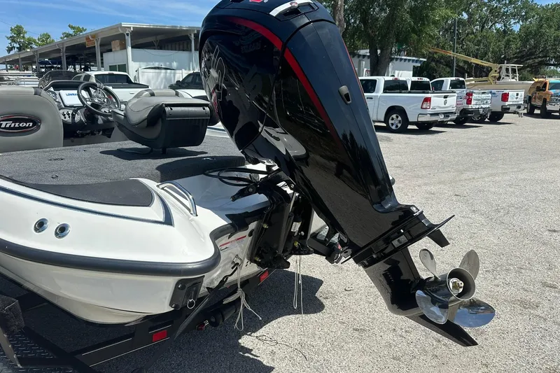 Slide: The Image of 2026 Triton 179 TrX boat with powerful outboard motor in a parking lot. - 26