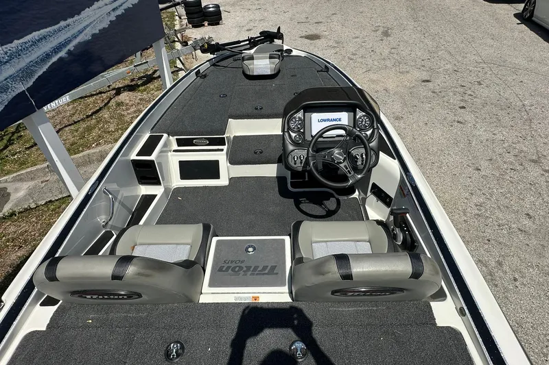 Slide: The Image of 2026 Triton 179 TrX boat interior with steering console and seating. - 8