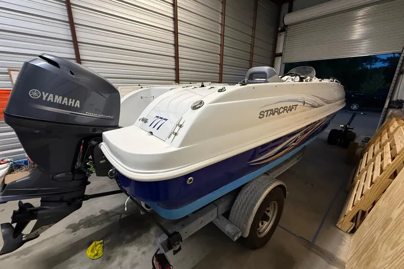 Slide: The Image of 2014 Starcraft 1915 OB Limited boat with Yamaha outboard motor in a garage. - 15