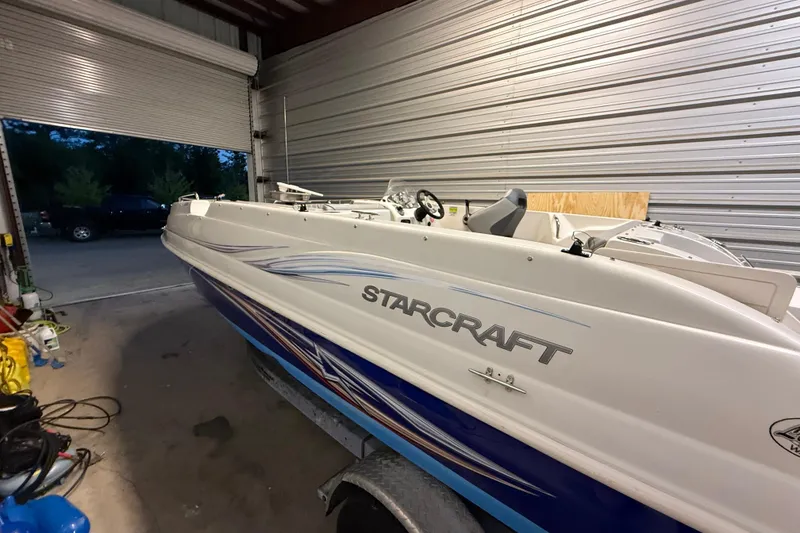 Slide: The Image of 2014 Starcraft 1915 OB Limited boat in a garage, showcasing sleek design and branding. - 16