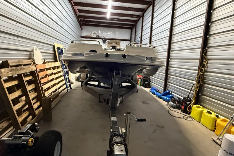 Slide: The Image of 2014 Starcraft 1915 OB Limited boat stored in a metal warehouse with equipment. - 3