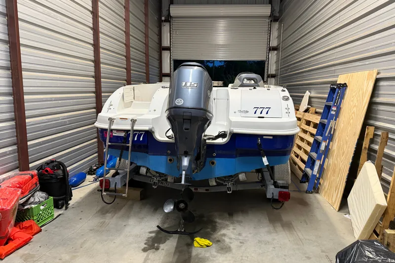 Slide: The Image of 2014 Starcraft 1915 OB Limited boat stored in a garage with equipment. - 9
