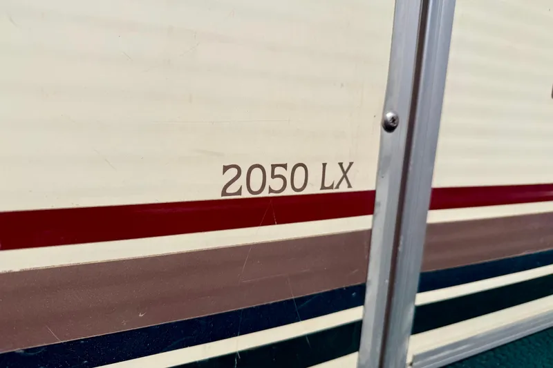 Slide: The Image of Close-up of 2001 Bennington 2050 LX boat model name on striped exterior. - 12