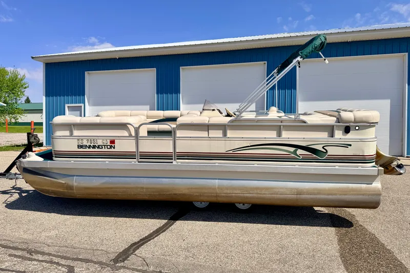 Slide: The Image of 2001 Bennington 2050 LX pontoon boat parked outside blue garage. - 3