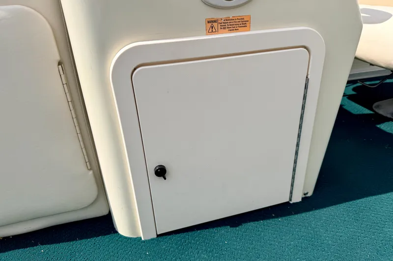 Slide: The Image of Storage compartment on a 2001 Bennington 2050 LX boat, featuring a white door and black handle. - 33