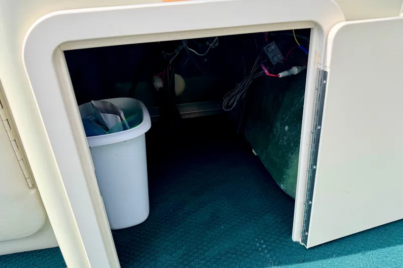 Slide: The Image of Storage compartment in a 2001 Bennington 2050 LX boat with a trash bin inside. - 34