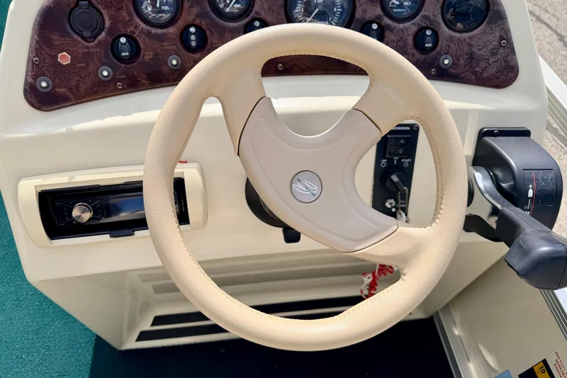 Slide: The Image of Steering wheel and dashboard of a 2001 Bennington 2050 LX boat, featuring control panel and gauges. - 38