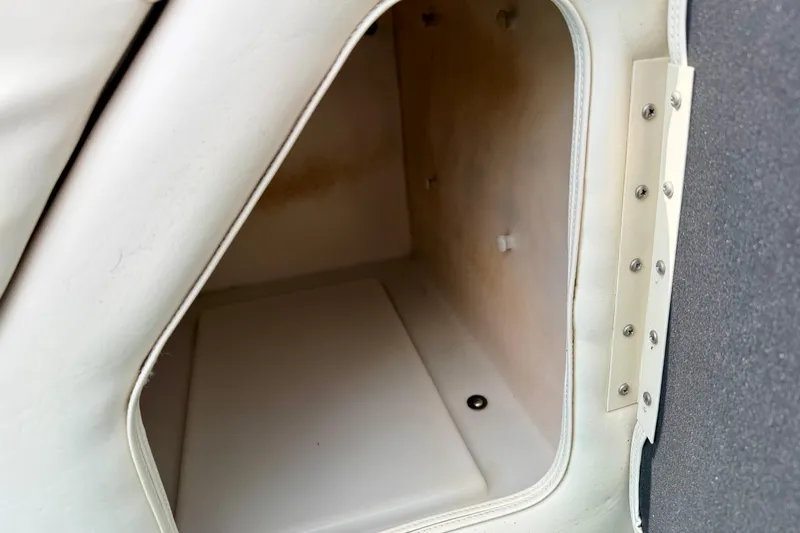 Slide: The Image of Storage compartment inside a 2001 Bennington 2050 LX boat, featuring white interior lining. - 46
