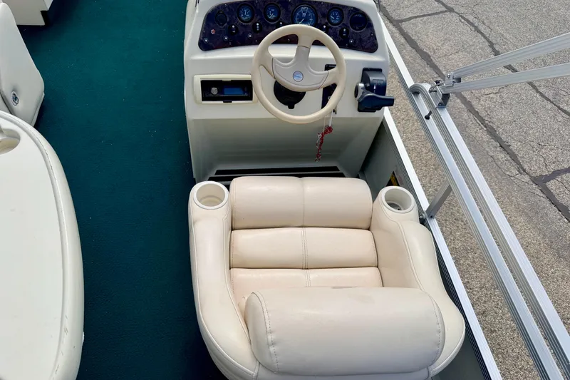 Slide: The Image of Captain's seat and helm of a 2001 Bennington 2050 LX boat with green carpet. - 60