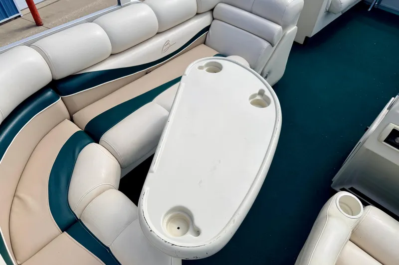 Slide: The Image of Interior of a 2001 Bennington 2050 LX boat with cushioned seating and table. - 61