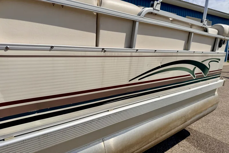Slide: The Image of Side view of a 2001 Bennington 2050 LX pontoon boat with decorative graphics. - 7