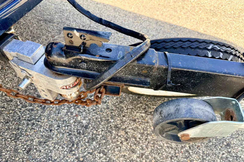 Slide: The Image of Trailer hitch and wheel of a 2001 Bennington 2050 LX on asphalt. - 72