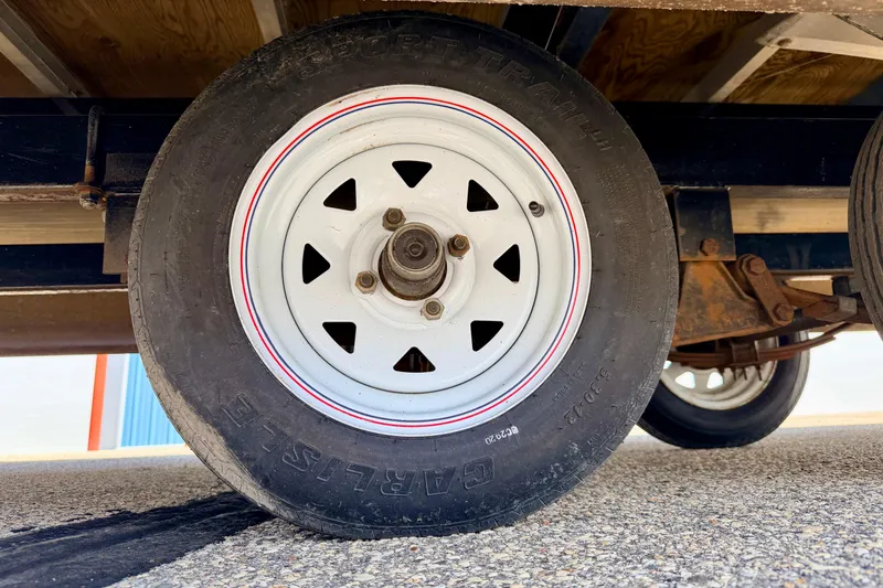 Slide: The Image of Trailer wheel with white rim and red stripe on a Bennington 2050 LX, 2001 model. - 73