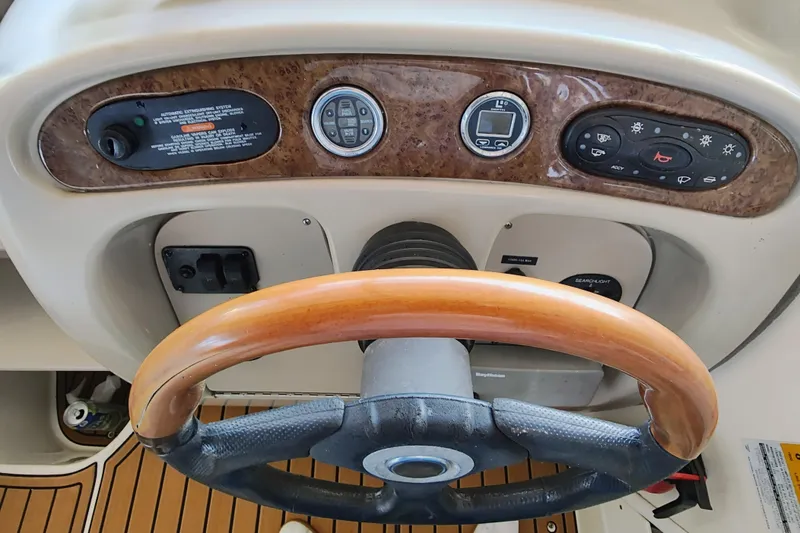 Slide: The Image of Steering wheel and dashboard of a 2001 Sea Ray Sundancer 260 boat. - 18