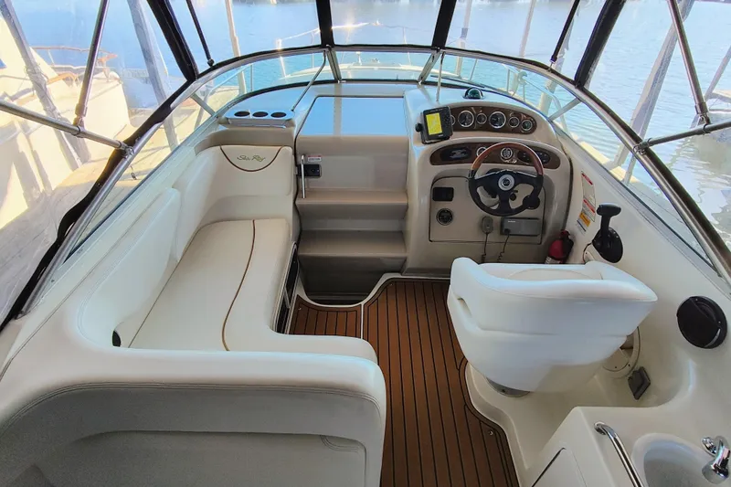 Slide: The Image of Cockpit of 2001 Sea Ray Sundancer 260 with steering wheel and seating, overlooking water. - 19