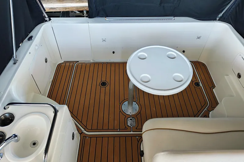 Slide: The Image of 2001 Sea Ray Sundancer 260 boat interior with teak flooring and round table. - 29