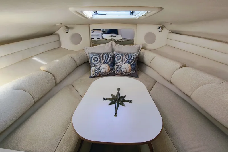 Slide: The Image of Interior of 2001 Sea Ray Sundancer 260 with cozy seating and decorative pillows. - 32
