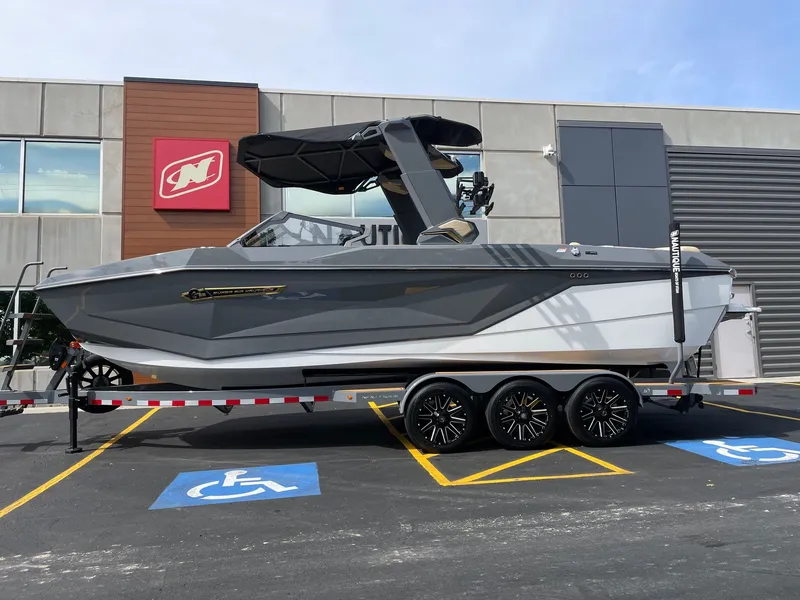 The Image of 2026 Nautique G25 boat on trailer in front of building. - 1