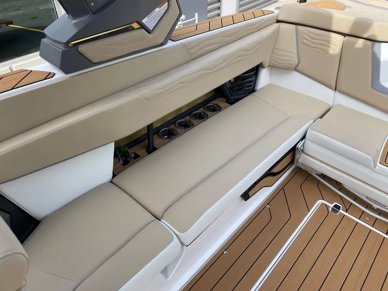 Slide: The Image of Interior of 2026 Nautique G25 with beige seating and cup holders. - 7