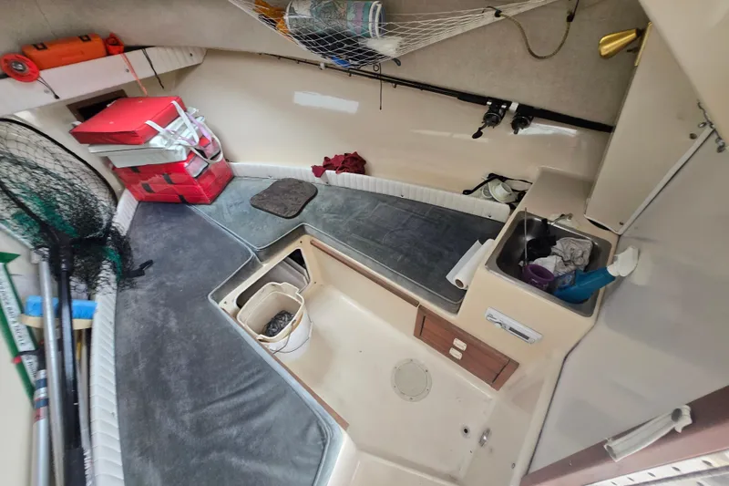 Slide: The Image of Interior of a 1989 Sea Ox 250C boat with fishing gear and storage. - 11