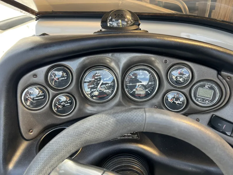 Slide: The Image of Dashboard of a 2003 Crownline 225 LPX boat with compass and gauges. - 12