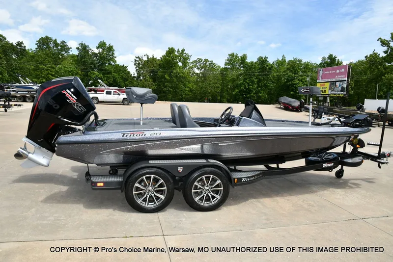 Slide: The Image of 2024 Triton 20XP Patriot boat parked on trailer outdoors. - 21