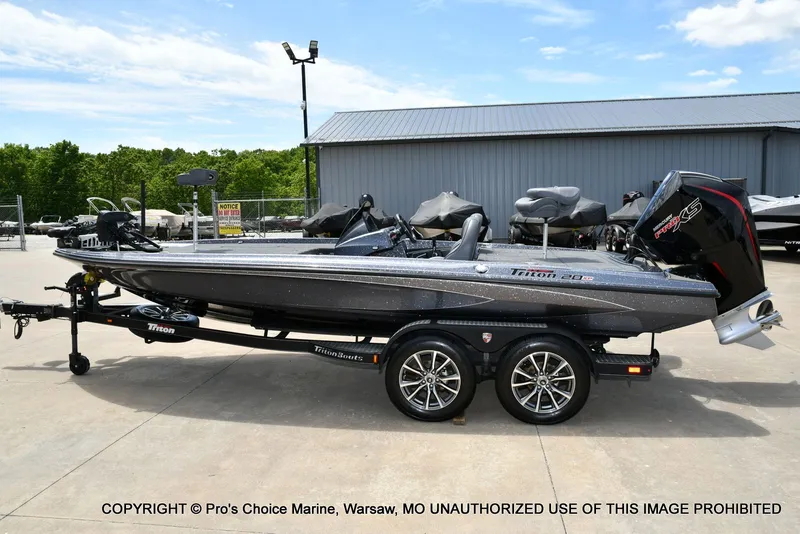 Slide: The Image of 2024 Triton 20XP Patriot boat on trailer outdoors. - 29