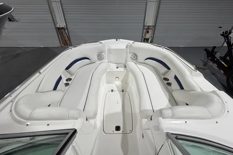 Slide: The Image of 2013 Hurricane SunDeck 2400 OB boat interior with white seating and blue accents. - 21