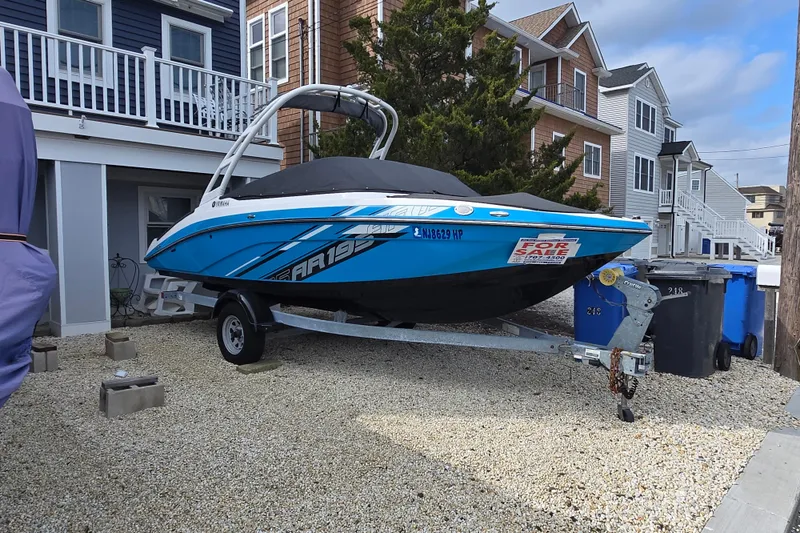 Slide: The Image of 2021 Yamaha Boats AR195 for sale, parked on a trailer in a residential area. - 20