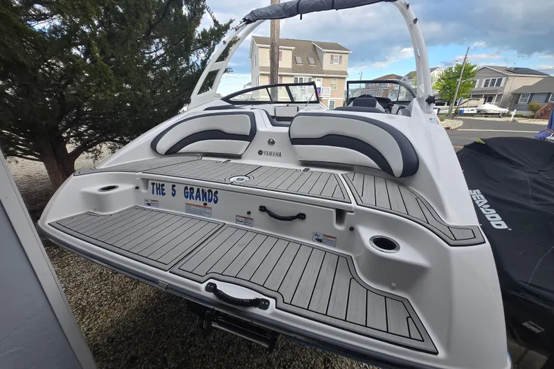 Slide: The Image of 2021 Yamaha Boats AR195 with custom deck, parked near houses and trees. - 4