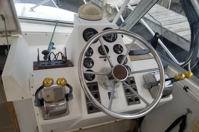 Slide: The Image of 1977 Bertram 28 Moppie boat helm with steering wheel and control panel. - 13