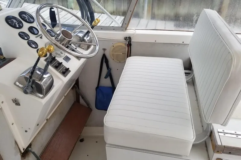 Slide: The Image of 1977 Bertram 28 Moppie boat interior with steering wheel and white seating. - 15