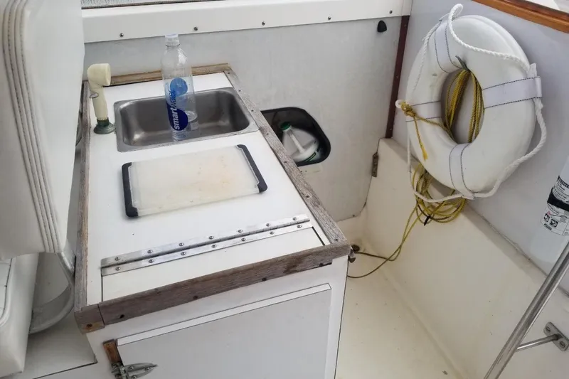 Slide: The Image of 1977 Bertram 28 Moppie boat interior with sink, cutting board, and life preserver. - 16