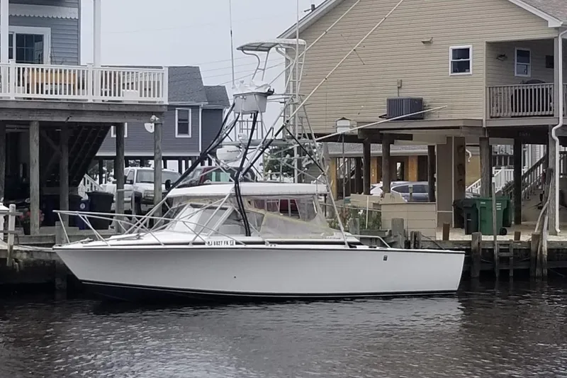 Slide: The Image of 1977 Bertram 28 Moppie boat docked near waterfront homes. - 19