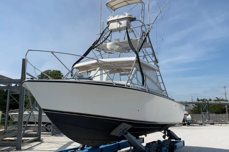Slide: The Image of 1977 Bertram 28 Moppie boat on trailer, displayed outdoors under clear sky. - 29