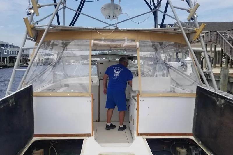 Slide: The Image of 1977 Bertram 28 Moppie boat with a person onboard at a marina. - 5