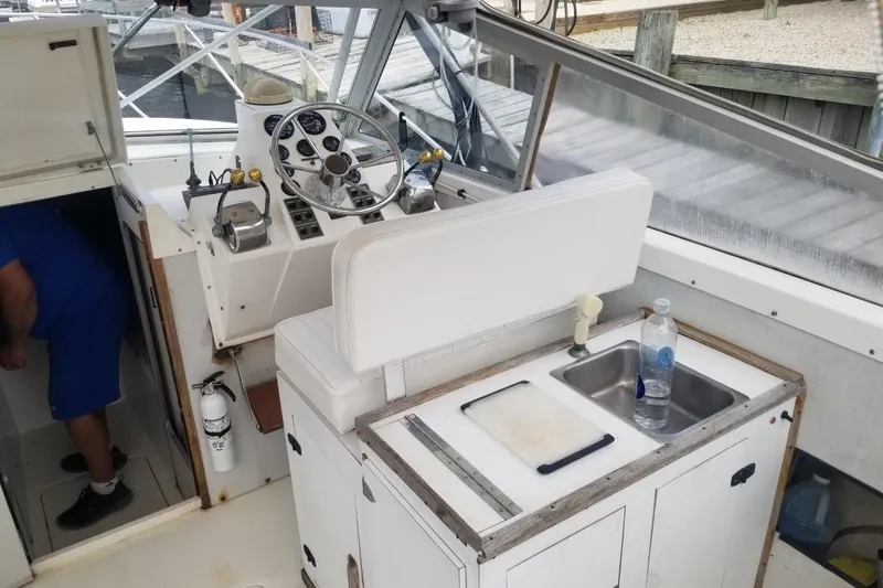 Slide: The Image of 1977 Bertram 28 Moppie boat interior with helm, sink, and storage area. - 8
