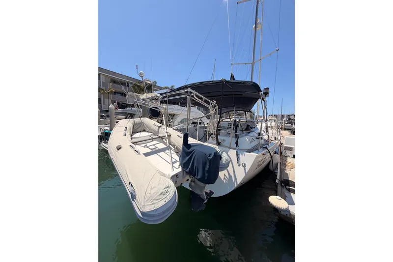 Slide: The Image of 2006 Hanse 461 yacht docked at marina, featuring inflatable dinghy and covered cockpit. - 10