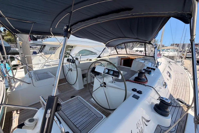 Slide: The Image of 2006 Hanse 461 yacht cockpit with dual steering wheels and covered deck in marina. - 13