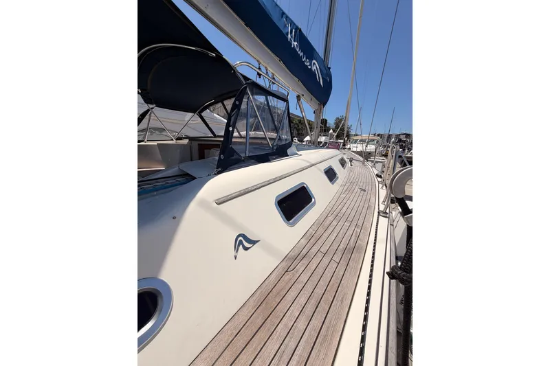 Slide: The Image of 2006 Hanse 461 sailboat with teak deck and blue canopy in marina. - 14