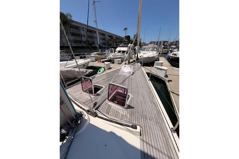 Slide: The Image of 2006 Hanse 461 yacht docked at marina, showcasing deck and open hatches. - 17